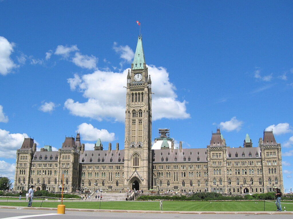 Tourists place in Canada showcasing Parliament Hill Ottawa illuminated at sunset with Gothic-style architecture